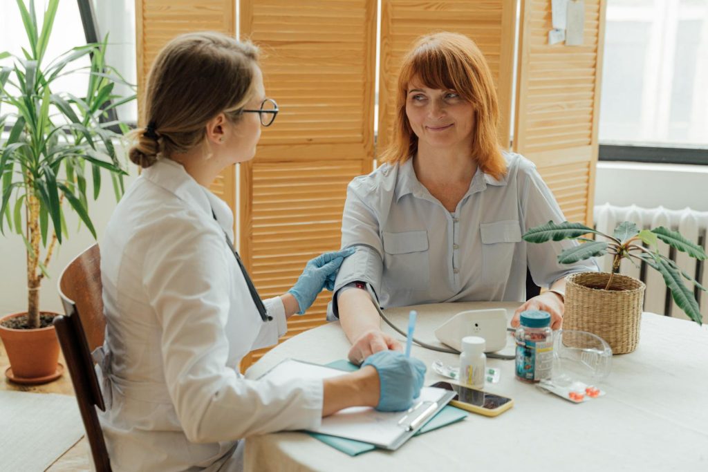 Médecin mesurant la tension artérielle d'un patient à l'aide d'un moniteur numérique dans un cadre clinique.