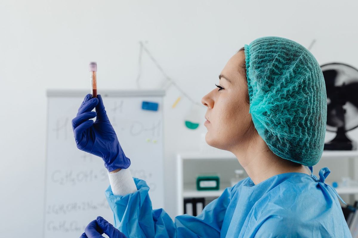 Femme en tenue de laboratoire tient un tube à essai pour observation