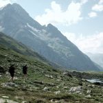 Hikers traverse a scenic mountain landscape